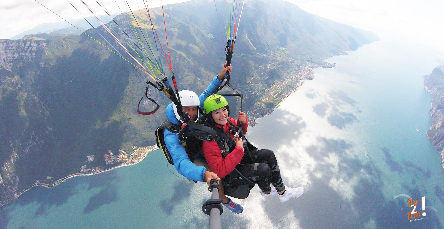 in-questa-immagine-vediamo-un-parapendista-professionista-su-un-parapendio-biposto-in-volo-sul-lago-di-Garda